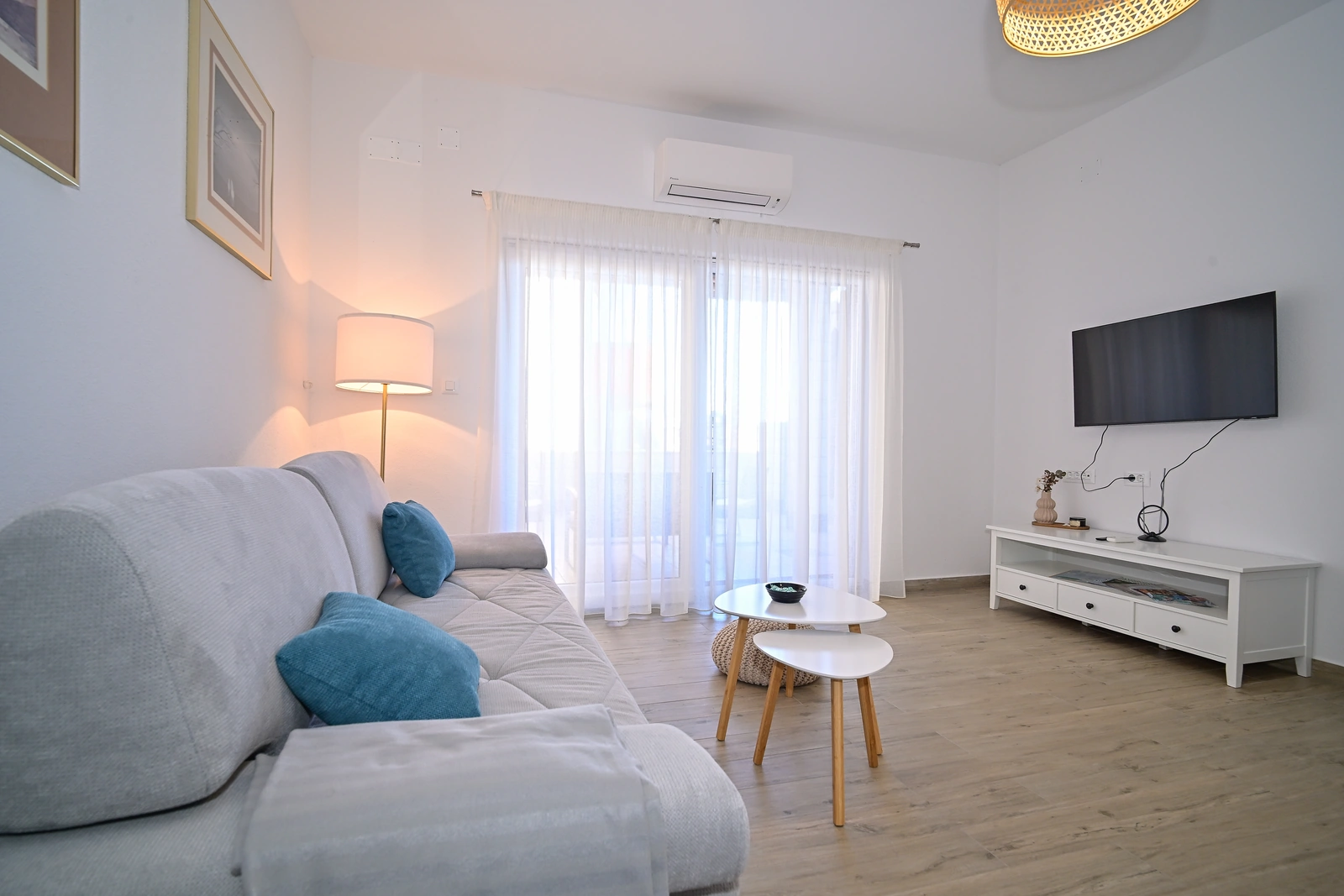 Svijetli dnevni boravak sa sofom, TV-om i klimom, apartman AMI Strožanac