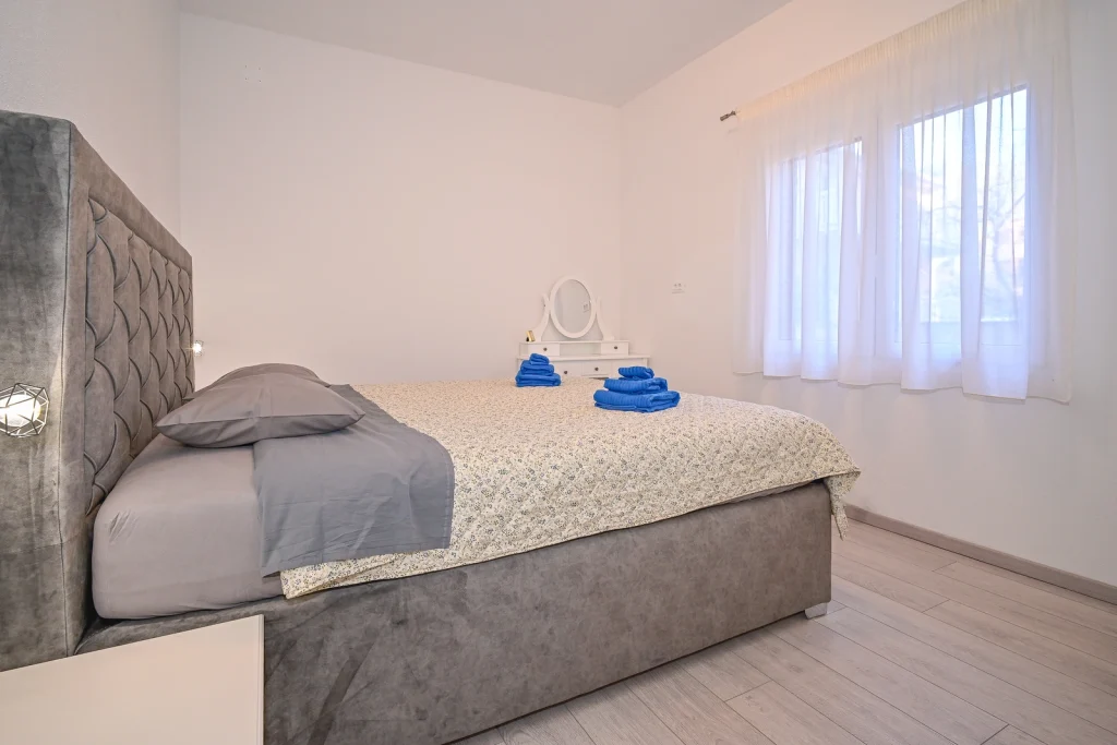 Bračni krevet uz prozor u spavaćoj sobi, apartman AMI Strožanac Split