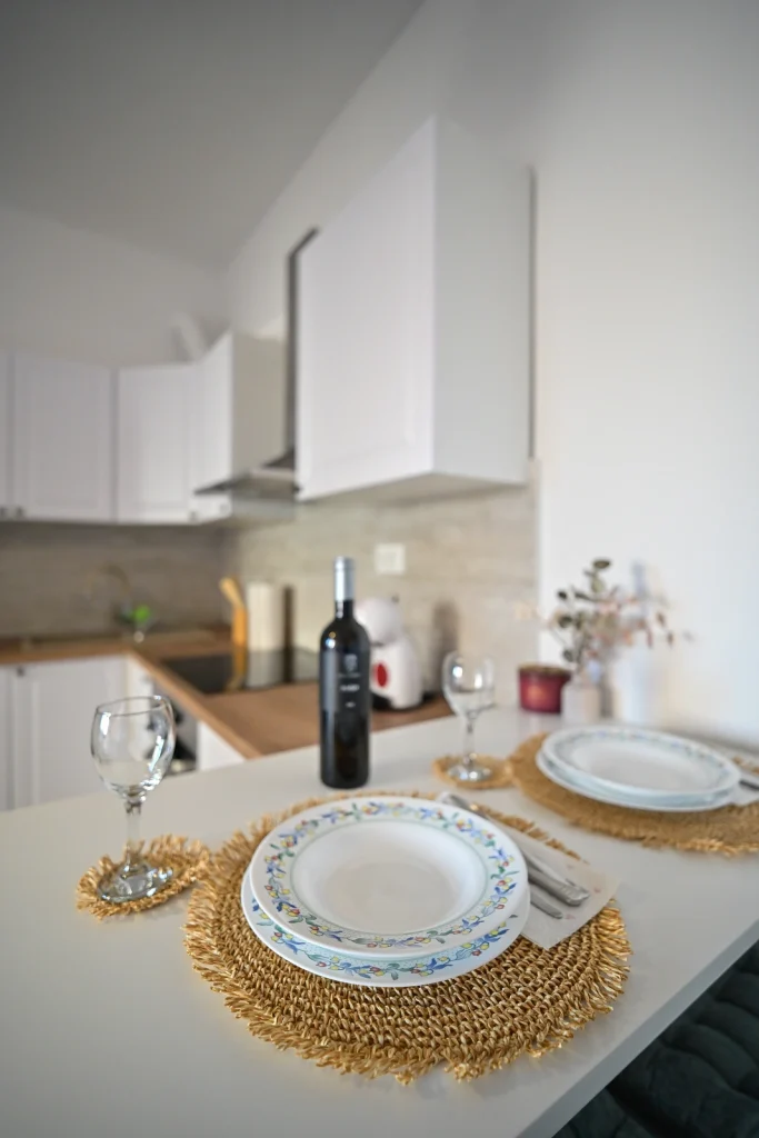 Detalj postavljenog stola sa servisom i vinom, apartman AMI Strožanac