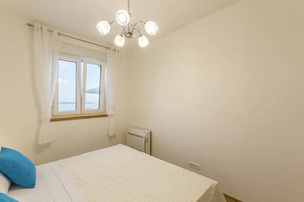 Spavaća soba s prozorom i pogledom na more, apartman Aquamarine Split