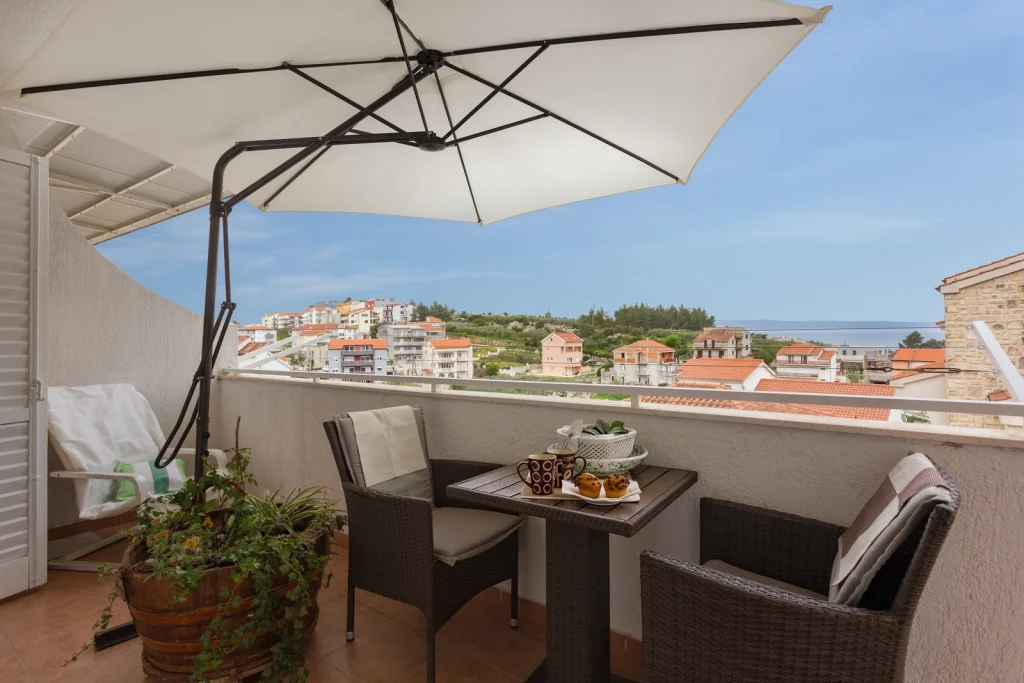 Natkriveni balkon sa suncobranom i pogledom na more u apartmanu Arca Strožanac