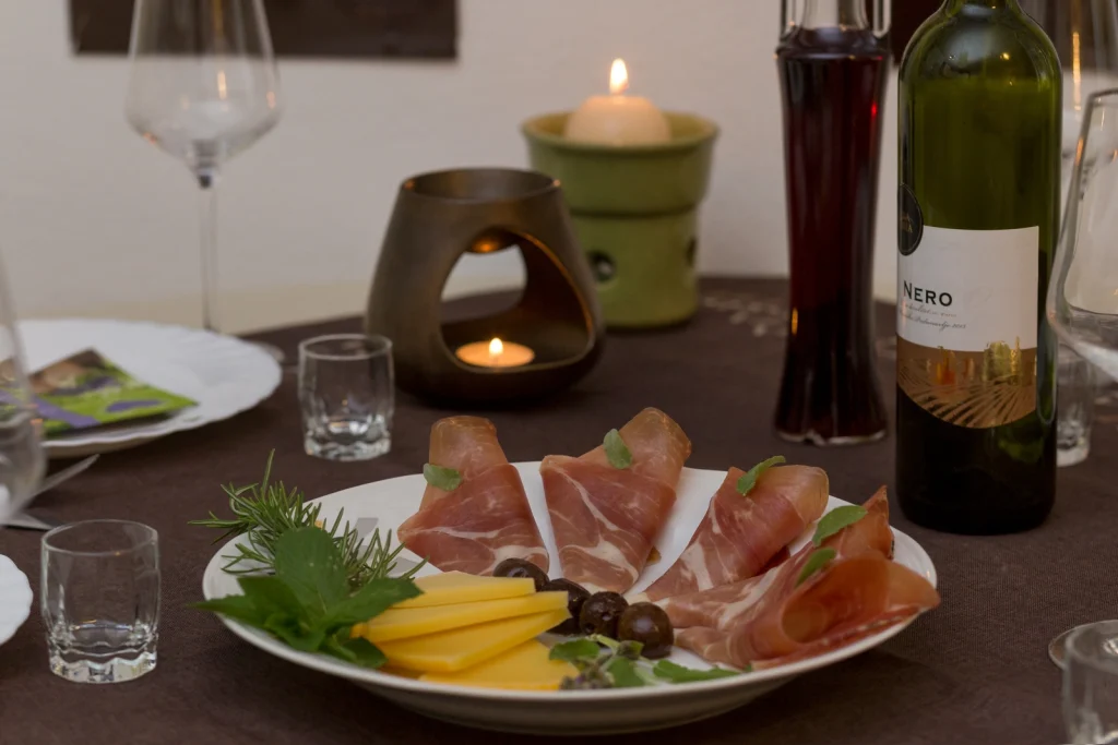 Tanjur dalmatinskog pršuta i sira uz čašu vina u apartmanu Arca Strožanac