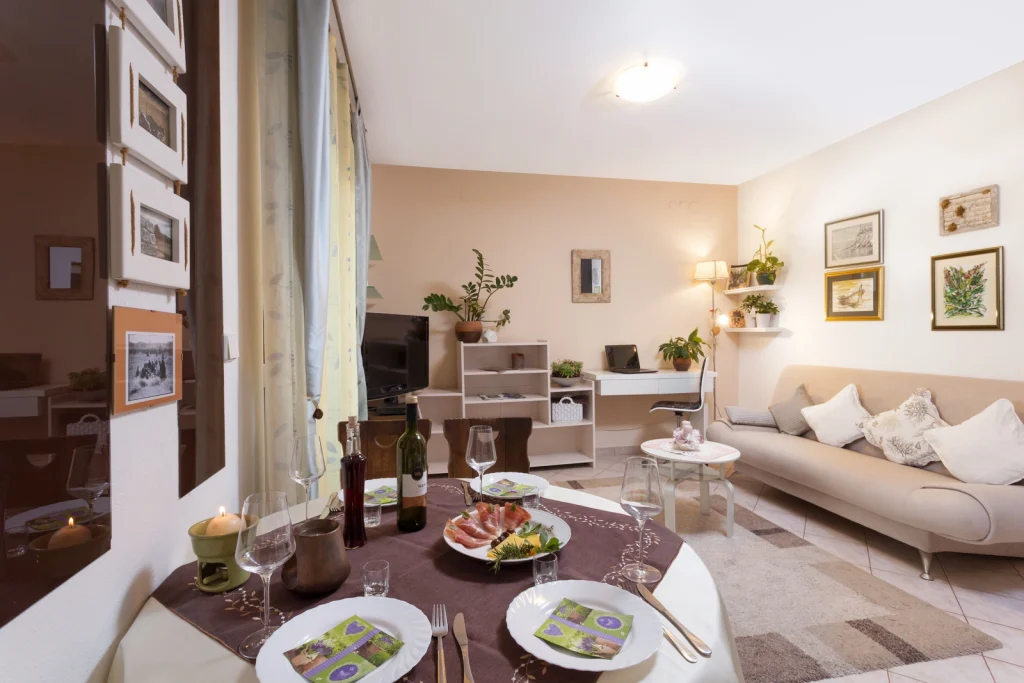 Dnevni boravak apartmana Arca s posluženim stolom i udobnim trosjedom, Strožanac