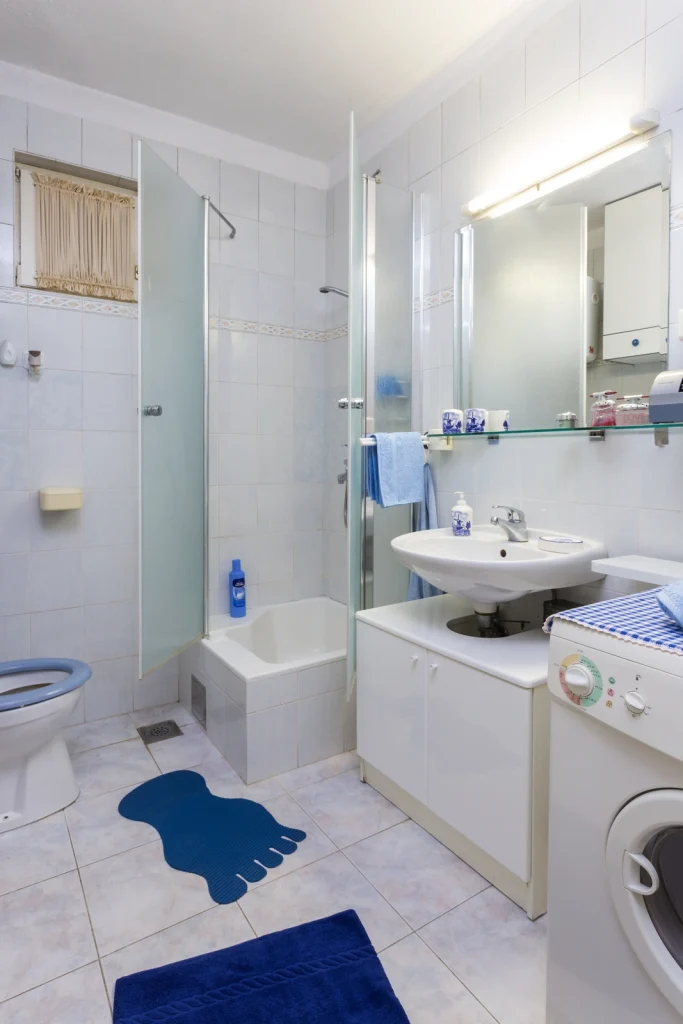 Svijetla kupaonica s umivaonikom, ogledalom i perilicom rublja, apartman Arca Strožanac