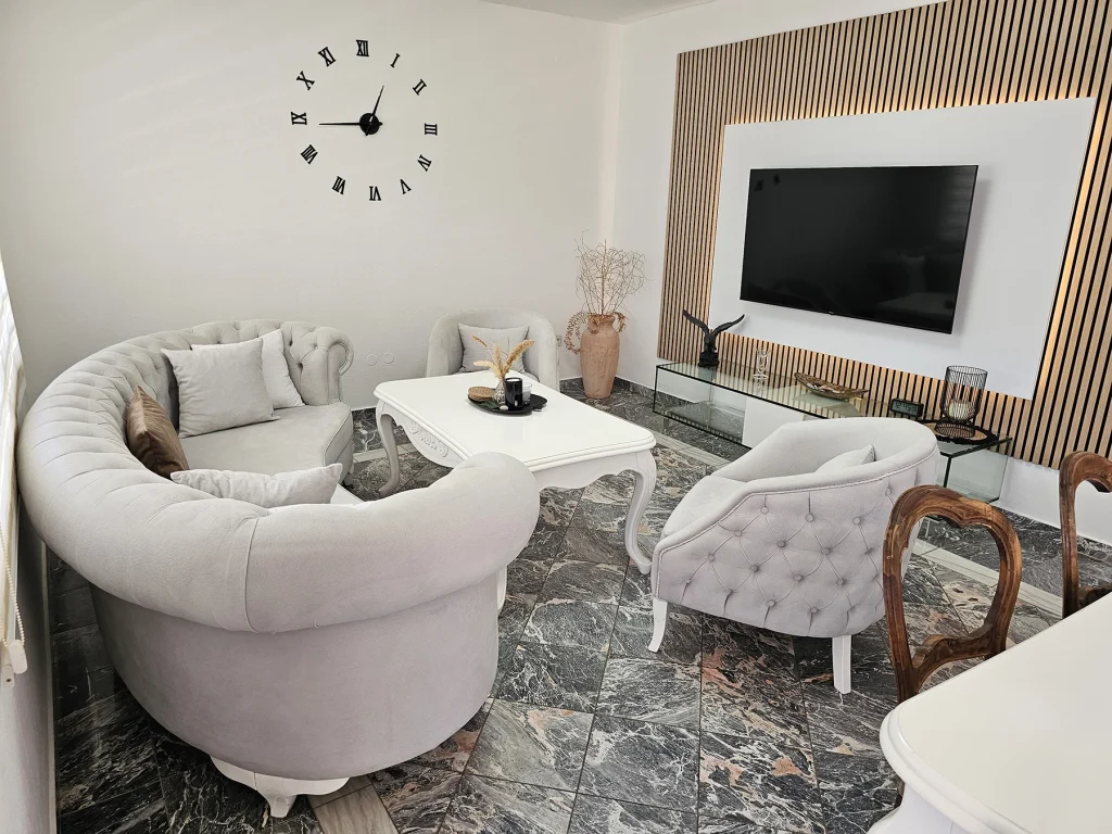 Dnevni boravak sa zaobljenom sofom i TV-om, apartman Breeze Split