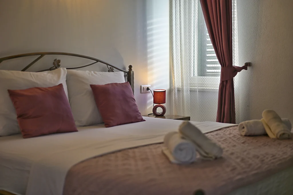 Krevet s ukrasnim jastucima uz prozor, apartman Briscola Split