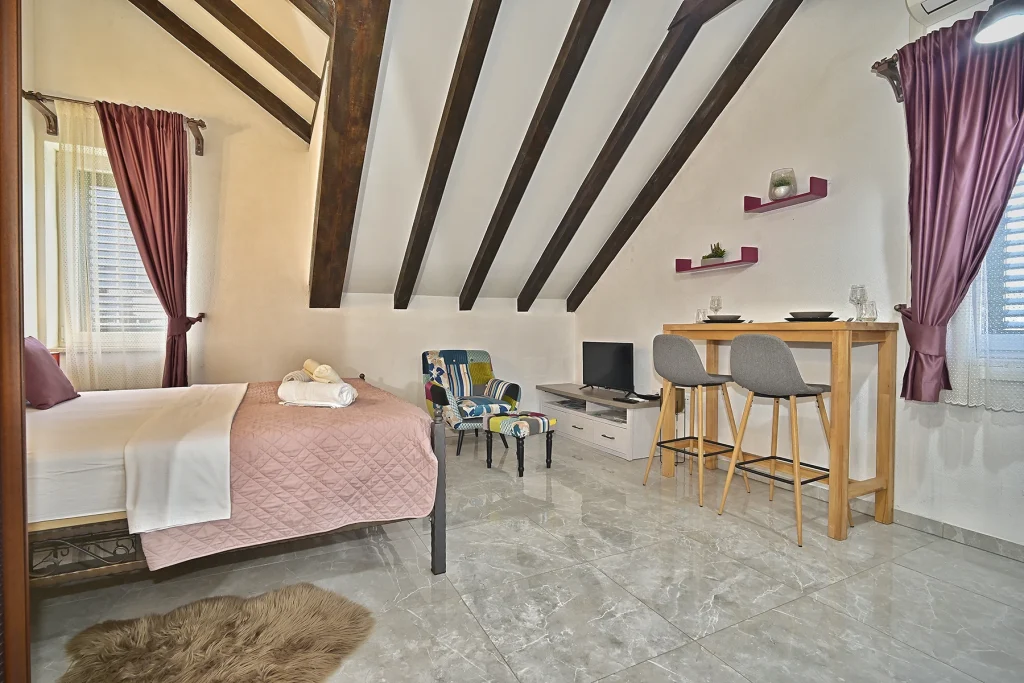 Studio u potkrovlju s krevetom i drvenim gredama, apartman Briscola Split