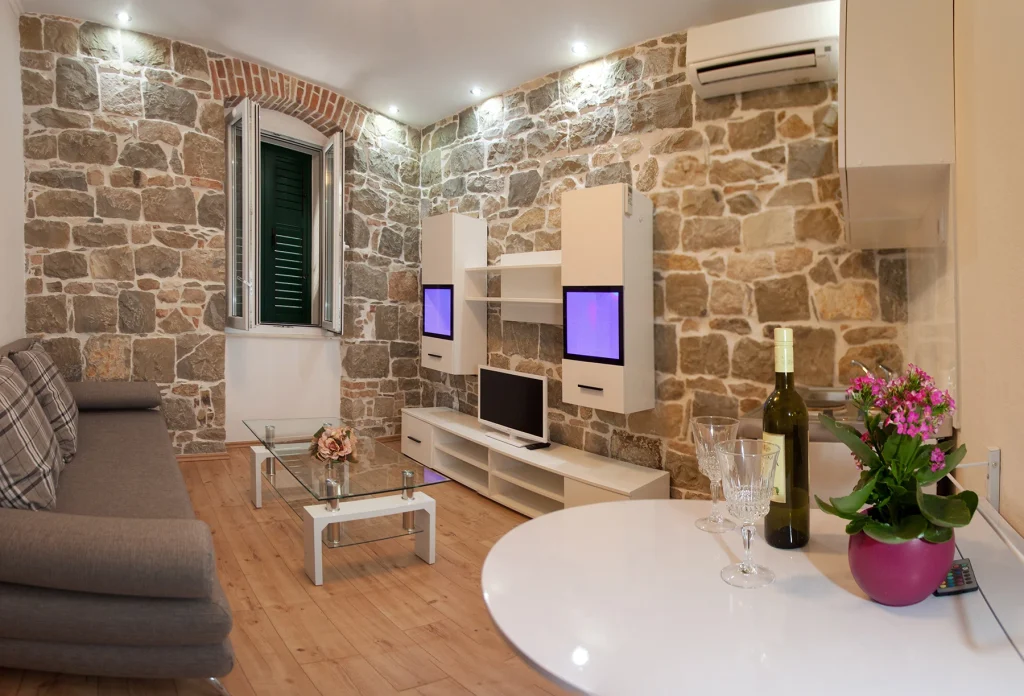 Dnevni boravak s kaučem, TV-om i kamenim zidom, apartman Casa Matošića 3 Split