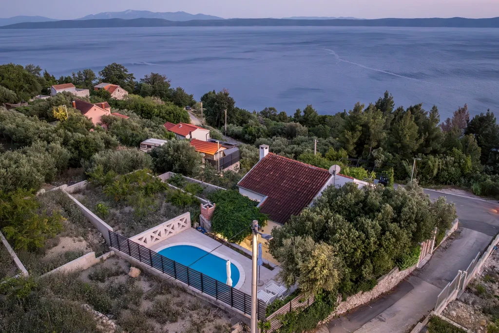 Zračni pogled na kuću s bazenom uz cestu, Podgora