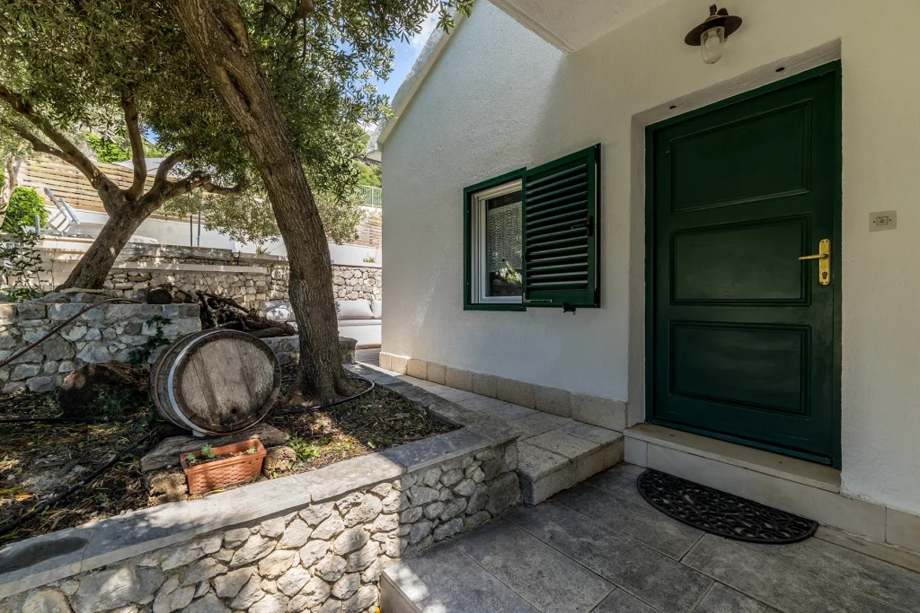 Kameni ulaz u kuću za odmor Domus Alta sa zelenim vratima, Podgora
