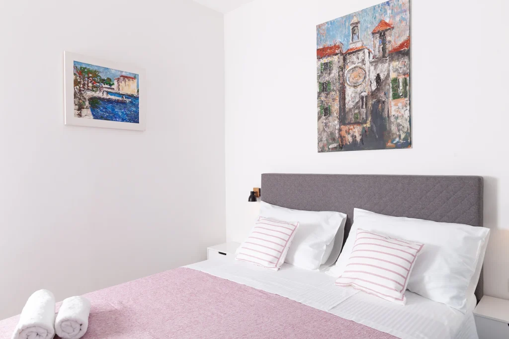 Spavaća soba s bračnim krevetom i umjetničkom slikom, apartman Roza Split