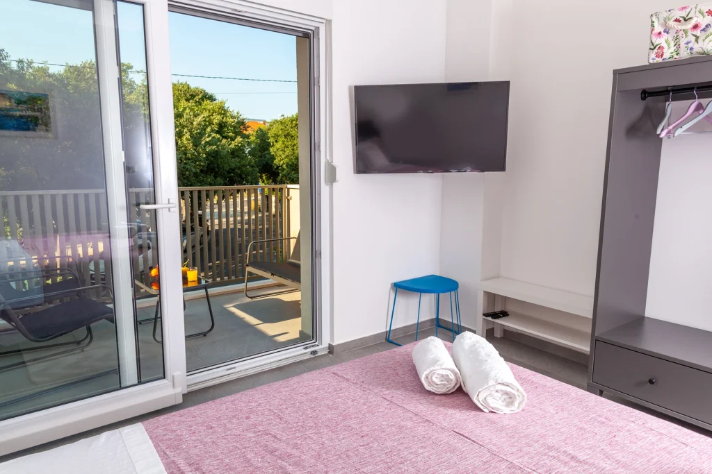 Spavaća soba s TV-om i izlazom na balkon, apartman Roza Split