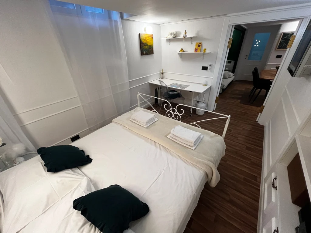 Krevet s radnim stolom uz zeleni zid, apartman Secret Room Split
