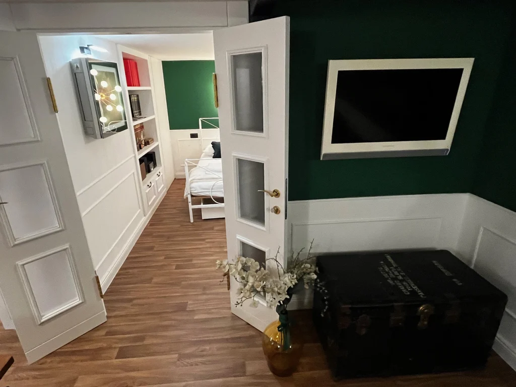 Spavaći kutak otvorenog tlocrta uz zeleni zid, apartman Secret Room Split