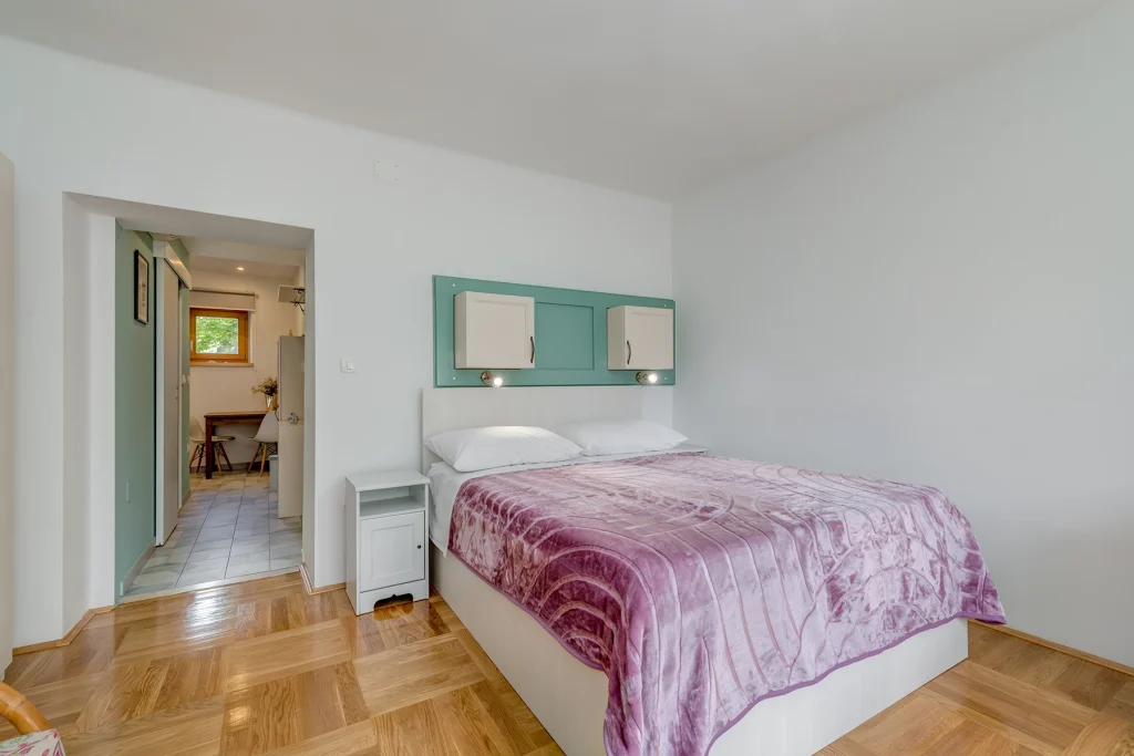 Spavaći kutak s krevetom i tirkiznim detaljima, apartman Lady Split