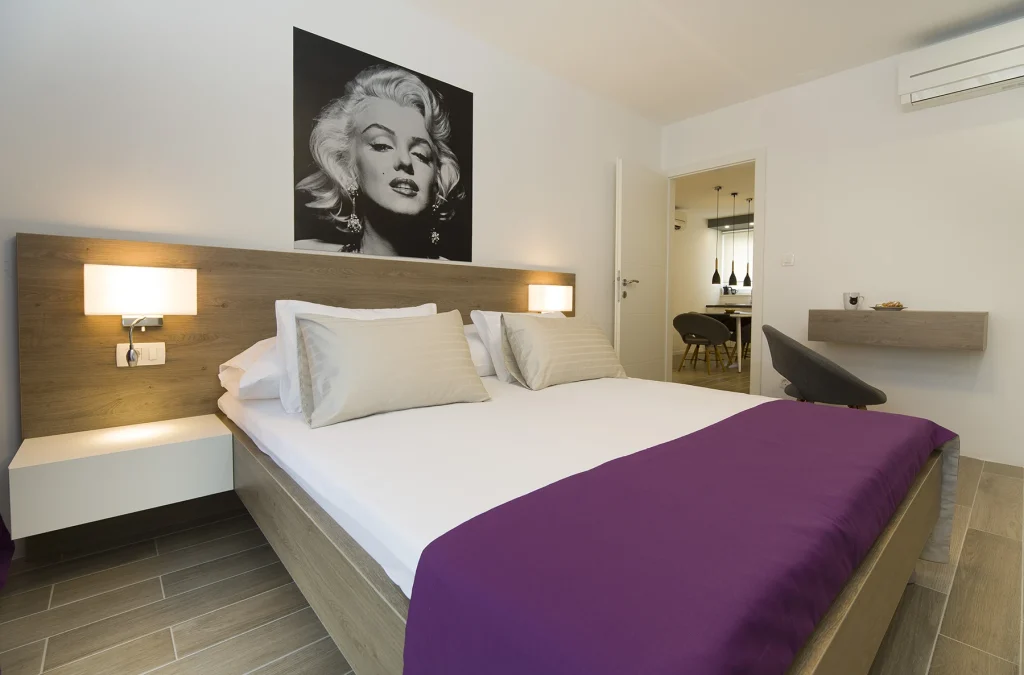 Spavaća soba s bračnim krevetom i fotografijom Marilyn Monroe, apartman Le Grey Split