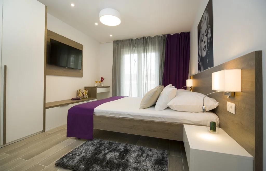 Spavaća soba s bračnim krevetom, TV-om i fotografijom Marilyn Monroe, apartman Le Grey Split