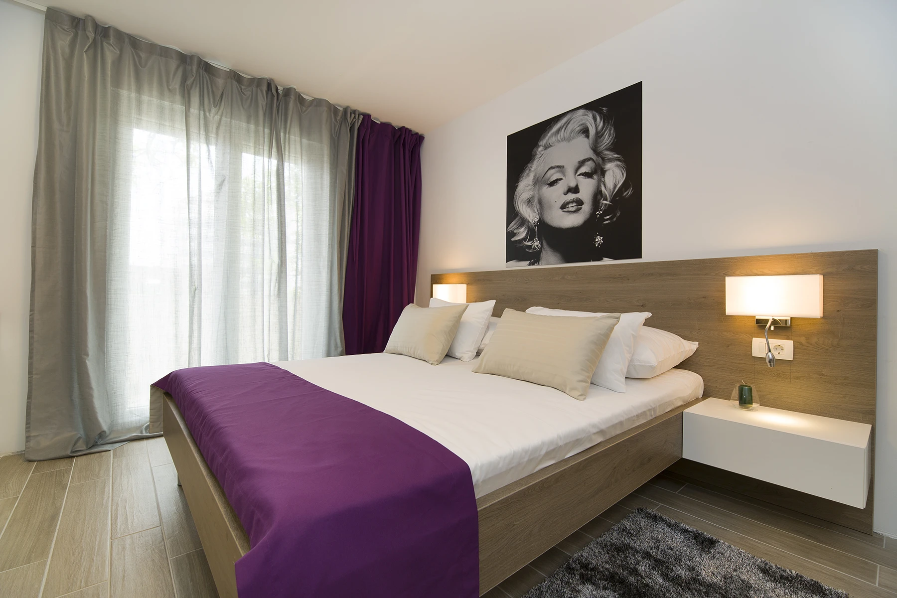 Spavaća soba s bračnim krevetom i fotografijom Marilyn Monroe, apartman Le Grey Split