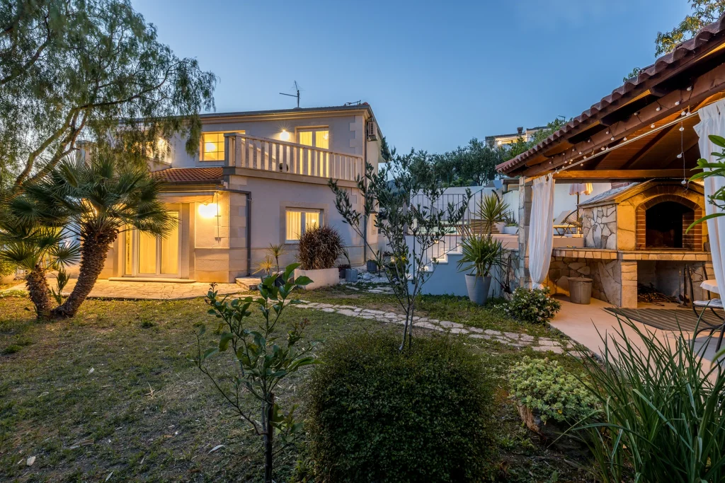 Eksterijer s osvijetljenom vilom i vrtom u sumrak, Villa Artea u Podstrani