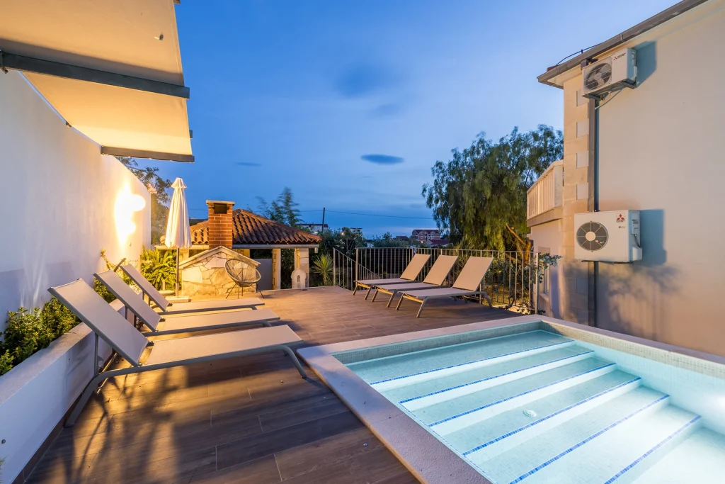 Bazen s vilom, bazenom i ležaljkama navečer, Villa Artea u Podstrani