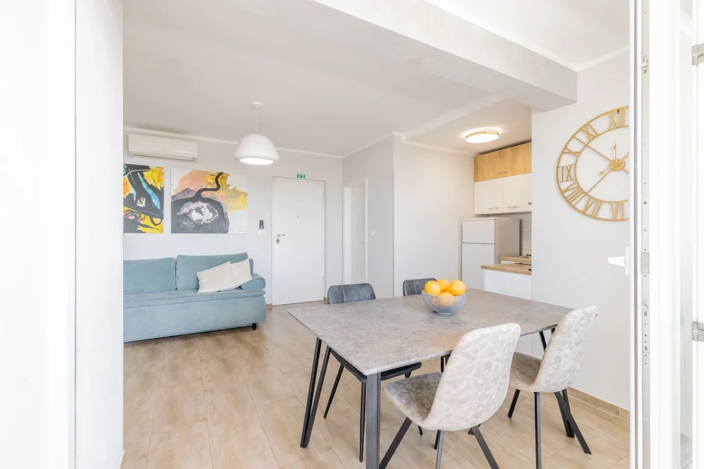 Garniturom, blagovaonicom i satom na zidu, apartman Vista Shine u Splitu